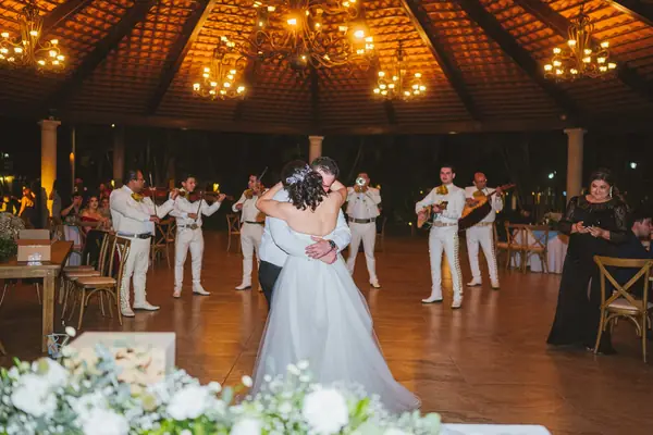 Pareja bailando en su boda mientras toca el mariachi
